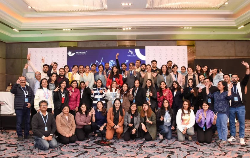 A large group of attendees and the team posing together in an event hall