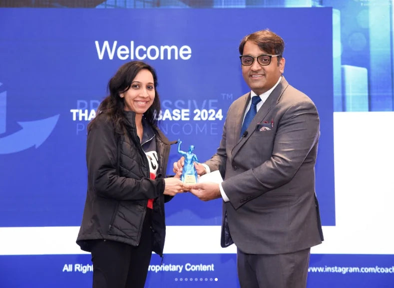 Anshul Kapoor presenting a trophy to an attendee on stage at BASE 2024