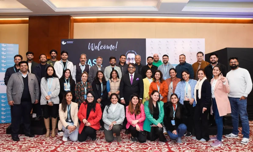 Attendees and the team standing together in front of a Welcome backdrop