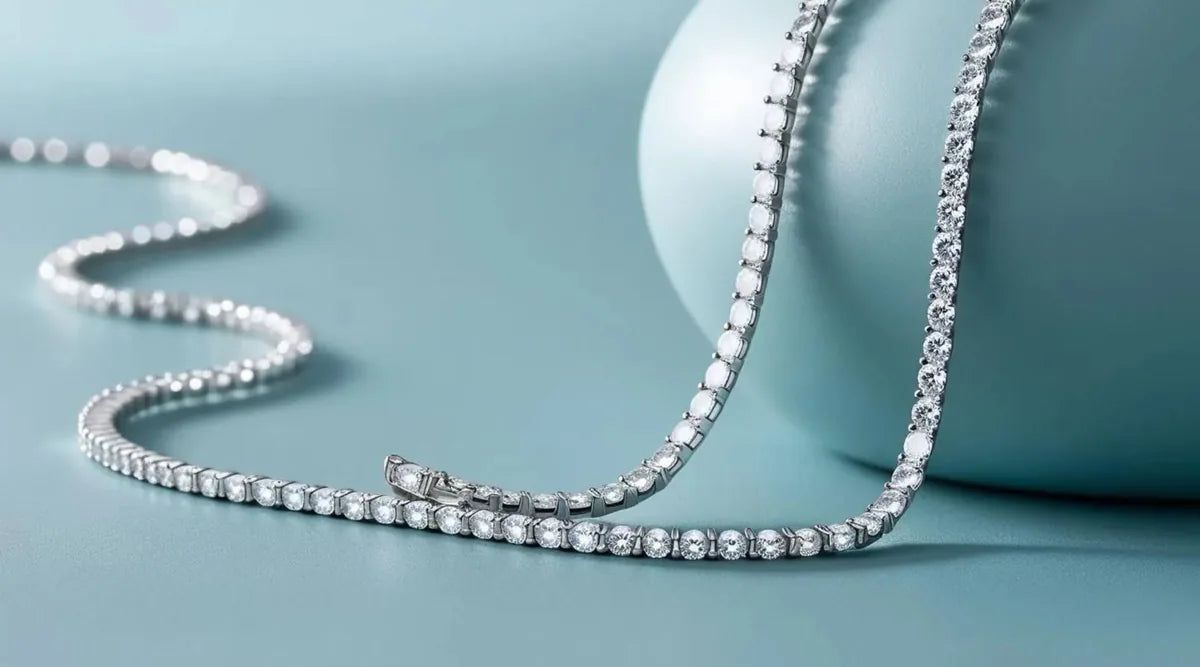 A diamond tennis necklace on a pale surface